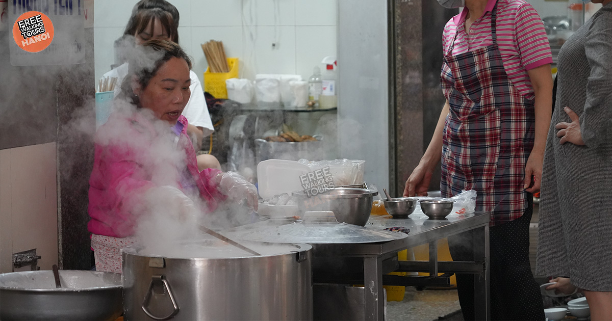 Vietnamese grandmother preparing bánh cuốn (steamed rice rolls) on the sidewalk in Hanoi